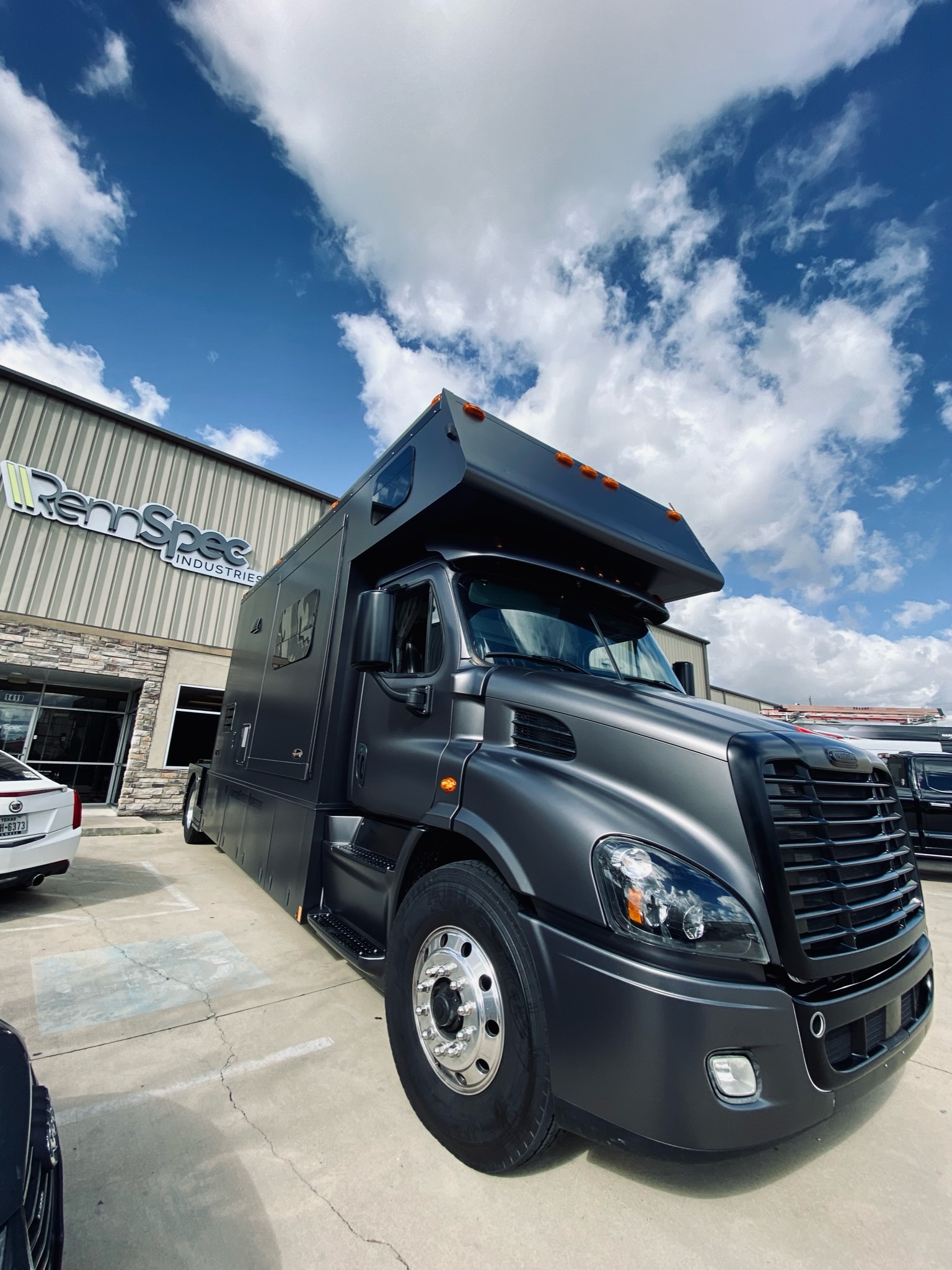 Matte black specialty truck wrap outside Rennspec Industries in Spring Texas