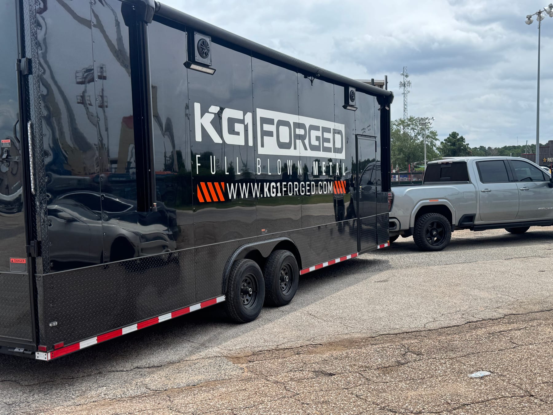 Black enclosed commercial trailer wrap with branded graphics